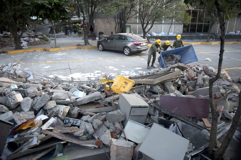 Soldiers, federal policemen and firefighters remove debris from the headquarters of state-owned Mexican oil giant Pemex in Mexico City on February 1, 2013