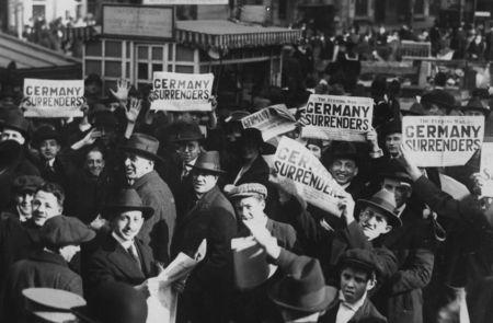 FILE PHOTO: A crowd in Times Square hold up copies of newspapers with a headline about the signing of the Armistice to end World War One, in New York, U.S., November 11, 1918. U.S. National Archives/via REUTERS