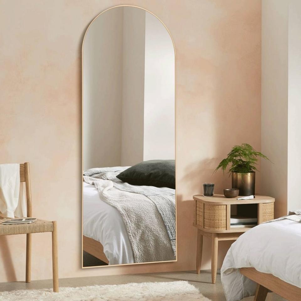 an arched mirror in gold