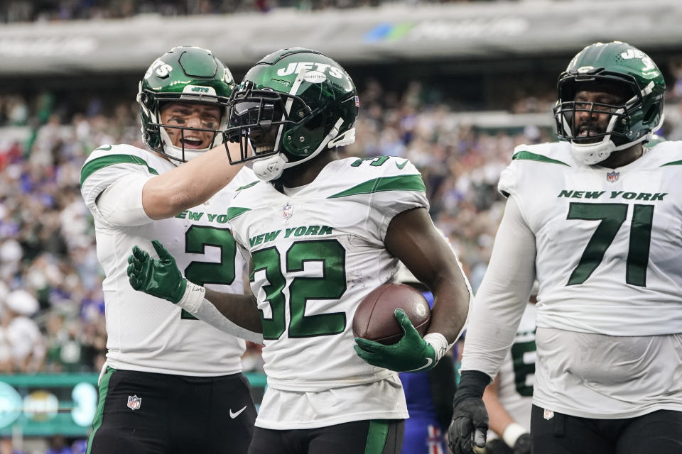 New York Jets quarterback Zach Wilson (2) celebrates with teammate Michael Carter (32) after Carter rushed for a touchdown during the first half of an NFL football game against the Buffalo Bills, Sunday, Nov. 6, 2022, in East Rutherford, N.J. (AP Photo/John Minchillo)