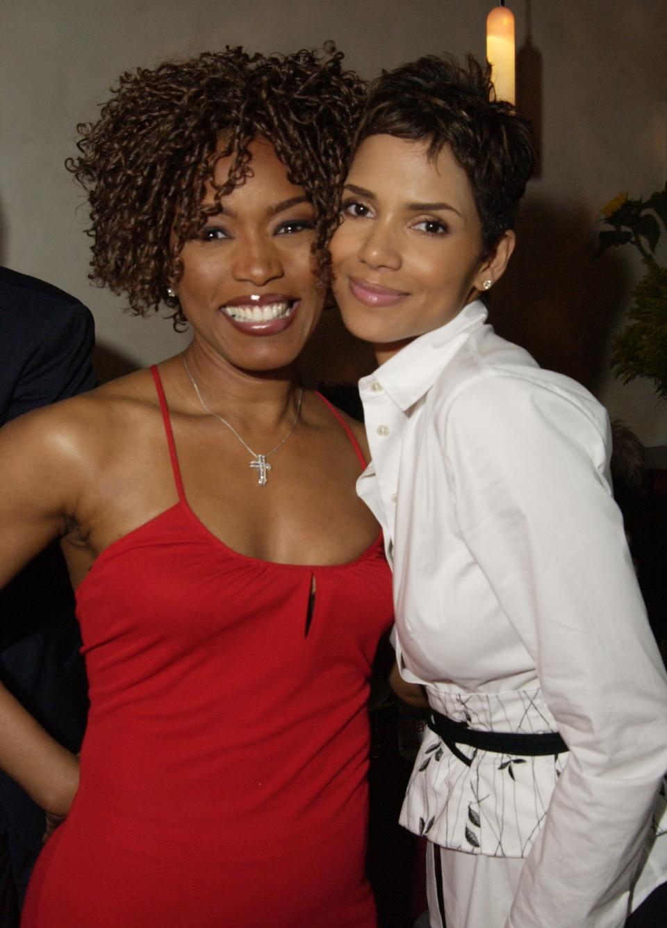 Angela Bassett and Halle Berry attend the Lion’s Gate Pre-Oscars party for ‘Monster’s Ball’ [Photo by Jeff Vespa Archive/WireImage].