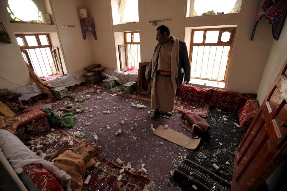 Un hombre muestra los daños en el interior de su casa después de un ataque aéreo en Okash, muy cerca de Saná.