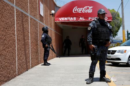 Police officers guard the entrance of the Coca-Cola FEMSA distribution plant after it closes down due to the issues of security and violence during the campaign rally of Independent presidential candidate Margarita Zavala (unseen) in Ciudad Altamirano, Guerrero state, Mexico April 3, 2018. REUTERS/Ginnette Riquelme/Files