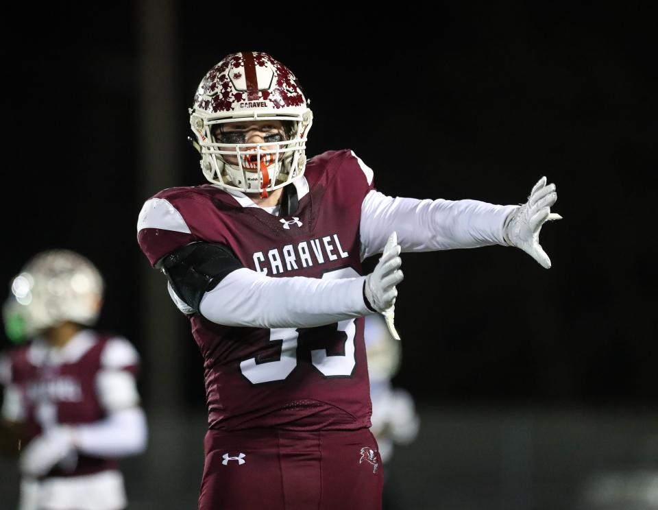 Caravel junior linebacker Brock Rhoades signals a Howard receiver caught the ball out of bounds in the Buccaneers’ 36-0 win over the Wildcats, Friday, Nov. 24, 2023 in a Class 2A DIAA football semifinal at Bob Peoples Stadium.
