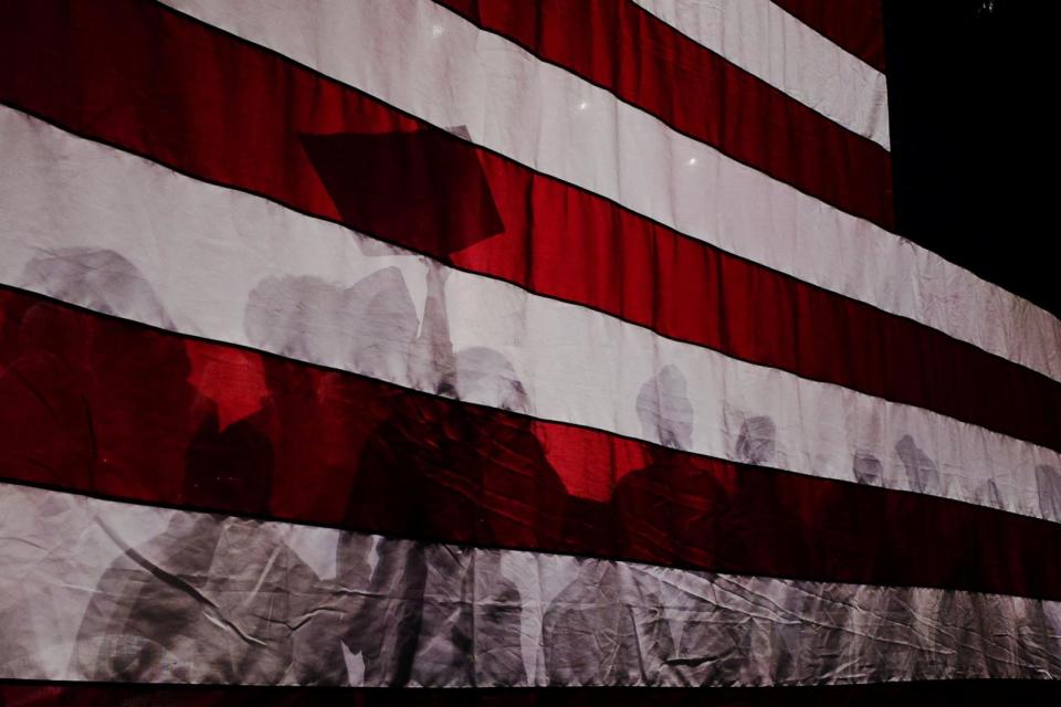 PHOTO: Supporters cast shadows on a U.S. flag at a Get Out the Vote campaign rally with Republican presidential candidate and former Ambassador to the United Nations Nikki Haley ahead of the New Hampshire primary election in Exeter, N.H., Jan. 21, 2024.   (Brian Snyder/Reuters)