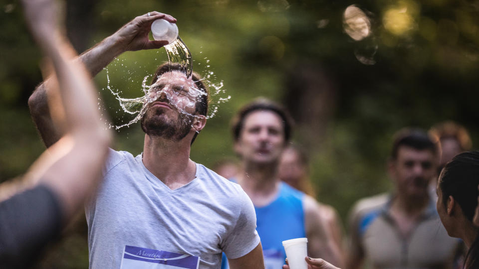  Marathon runner pouring water on himself. 