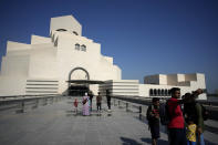 People walk outside the Museum of Islamic Art in Doha, Qatar, Tuesday, Nov. 22, 2022. For many of the visitors descending on Qatar for The World Cup, Doha's Museum of Islamic Art provides a peek into diverse aspects of Muslim heritage, art and craftmanship. The collection at MIA, as the museum is known, spans three continents and many centuries. (AP Photo/Christophe Ena)