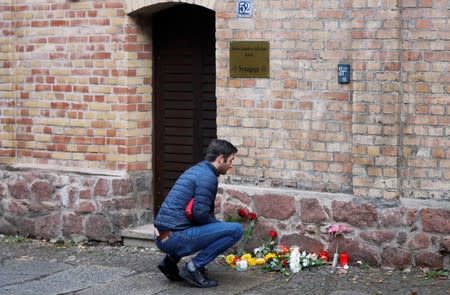 A man lays flowers outside the synagogue in Halle