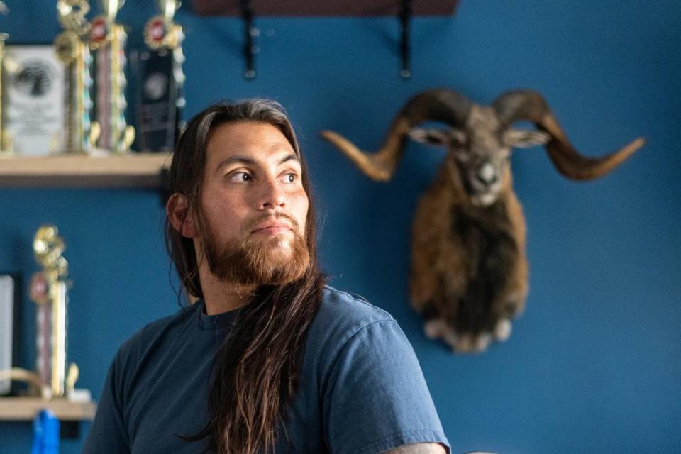 Jose Martinez sits near some trophies at his home in Apple Valley on Aug. 24, 2022. He says psychedelic mushrooms have allowed him to regain his life after losing three limbs in combat in Afghanistan. He became a champion para surfer.