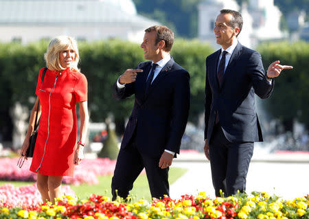 French President Emmanuel Macron (C), his wife Brigitte and Austrian Chancellor Christian Kern pose for photographers in Salzburg, Austria, August 23, 2017. REUTERS/Heinz-Peter Bader