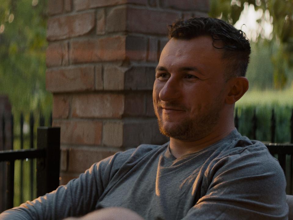 Johnny Manziel sits on a porch at sunset.