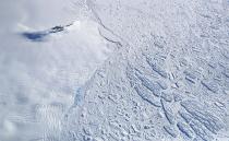 <p>Icebergs and sea ice (right) float next to land ice (left), as seen from NASA’s Operation IceBridge research aircraft, near the coast of the Antarctic Peninsula region, on Nov. 3, 2017, above Antarctica. (Photo: Mario Tama/Getty Images) </p>