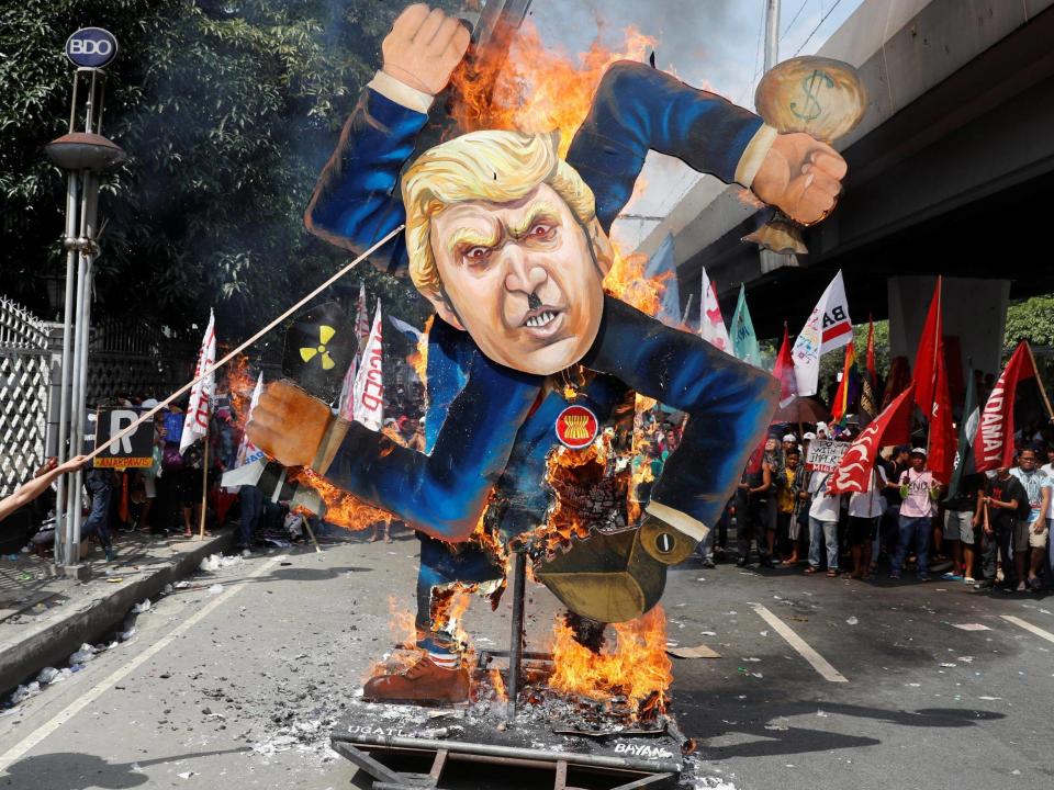 Trump in Philippines: President hails 'red carpet like nobody has ever received' while Manila protesters burn effigy of him