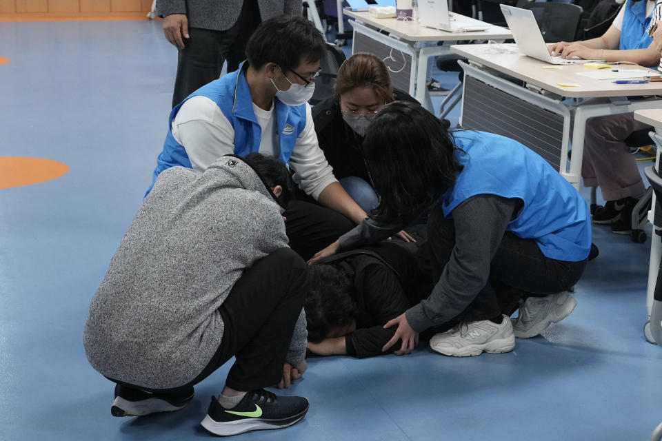 A parent of a victim of Saturday night's accident following Halloween festivities reacts at a community service center in Seoul, South Korea, Sunday, Oct. 30, 2022. In this ultra-wired, high-tech country, anguish, terror and grief, as well as many of the details of what happened, are playing out most vividly on social media. Users posted messages desperately seeking friends and loved ones, as witnesses and survivors described what they went through. (AP Photo/Ahn Young-joon)
