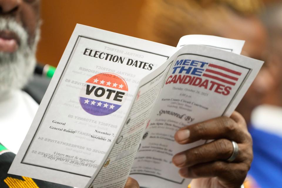 An attendee to a candidates forum reviews the event program that list those people seeking a statewide office in the November 7 election, in addition to a reminder of the general election and the general runoff of Nov. 28, in Vicksburg, Miss., on Oct. 26, 2023.
