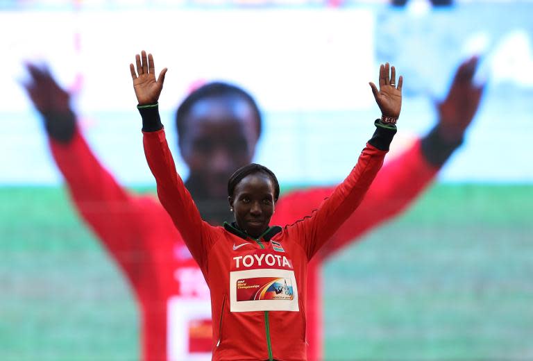 Kenya's Edna Kiplagat waves on the podium during the medal ceremony for the women's marathon at the 2013 IAAF World Championships in Moscow on August 10, 2013