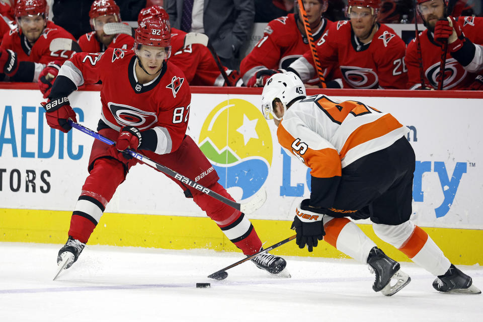 Carolina Hurricanes' Jesperi Kotkaniemi (82) controls the puck when challenged by Philadelphia Flyers' Cam York (45) during the second period of an NHL hockey game in Raleigh, N.C., Thursday, March 9, 2023. (AP Photo/Karl B DeBlaker)