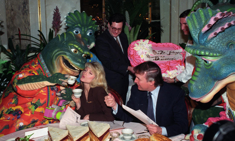 Donald Trump watches as Marla Maples gets a kiss from Earl Sinclair of TV's "Dinosaurs" during lunch at the Trump Plaza Hotel on Nov. 2, 1992.