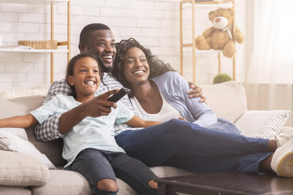 a family watching TV on the couch together