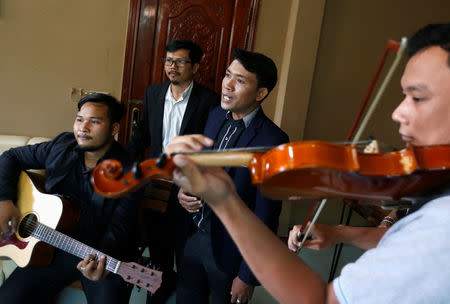 Yorn Young (2nd R) sings before a news conference in Phnom Penh, Cambodia, March 6, 2018. REUTERS/Samrang Pring