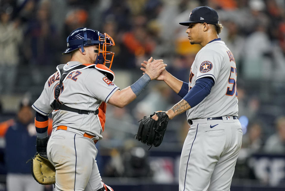 Houston Astros catcher Christian Vazquez (9) and relief pitcher Bryan Abreu (52) celebrate after the Astros beat the New York Yankees 5-0 in Game 3 of an American League Championship baseball series, Saturday, Oct. 22, 2022, in New York. (AP Photo/John Minchillo)