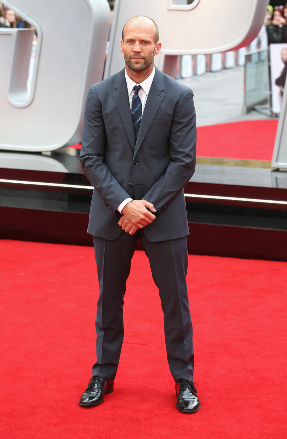 Jason Statham matched his dark gray suit to London’s dark gray skies. His somber face and striped tie coordinated with the blue ambiance as well.