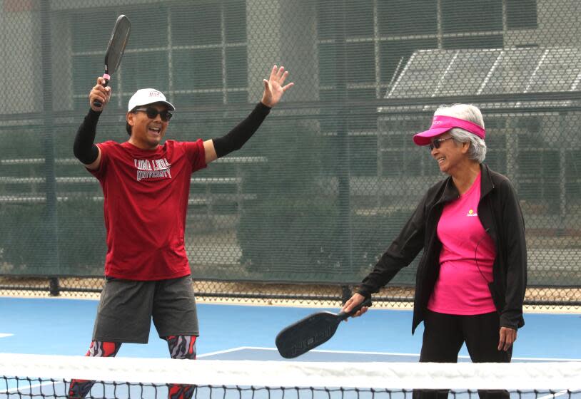 LOMA LINDA, CA - NOVEMBER 30, 2023 - Dr. Loida Medina, 85, right, and her son Ernie Medina, 58, celebrate a point during a game of pickleball at the Loma Linda University Drayson Center in Loma Linda on November 30, 2023. Dr. Medina, retired from working at Loma Linda University Medical Center, plays pickleball three days a week. Dr. Medina, a member of the Seventh Day Adventist Church, believes in a healthy, active lifestyle. Loma Linda is considered to be one of many Blue Zones in the world where longevity of life is found in seniors in these communities. Blue zones are regions in the world where people are claimed to live, or to have recently lived, longer than average. A recent Netflix mini series, "Live to 100: Secrets of the Blue Zones," claims Loma Lindans live longer due to faith, diet, and exercise. The notion is not based on scientific evidence but demographic anecdotes. (Genaro Molina / Los Angeles Times)