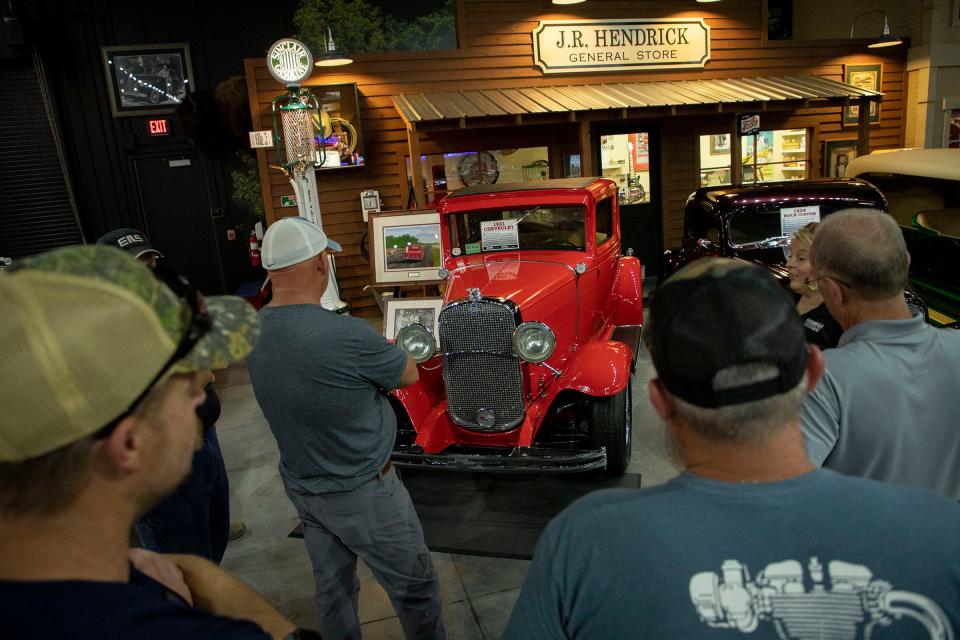 A tour group pauses at a display showing Rick Hendrick's first car, a 1931 Cherry Red Chevrolet, inside Hendrick's 58,000-square-foot Heritage Center in Concord, North Carolina, on July 25, 2023. Hendrick is one of the top Corvette collectors in the world. He owns 220 collector cars in the Heritage Center, 122 of which are rare Corvettes.