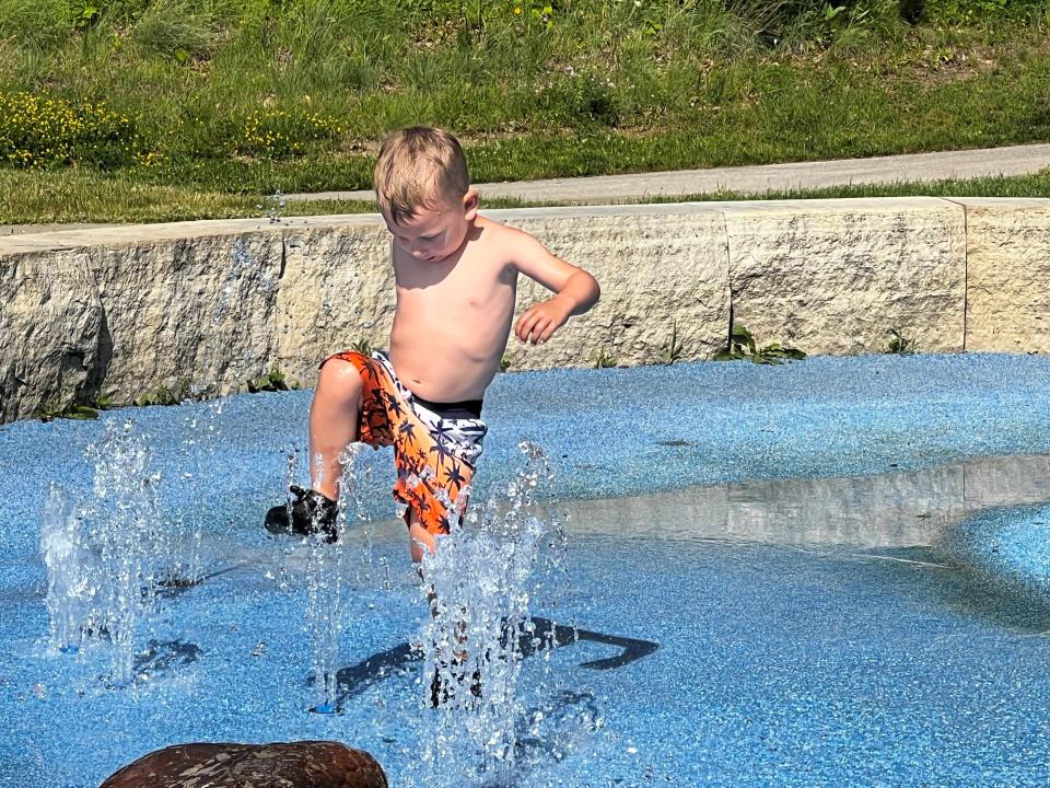 In order to get wetter, Benji stomps on the water as it flows up in a geyser.