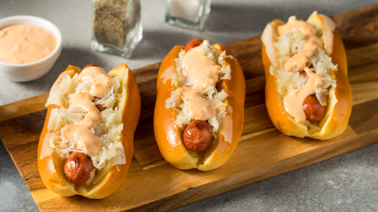 hot dogs with sauerkraut on cutting board
