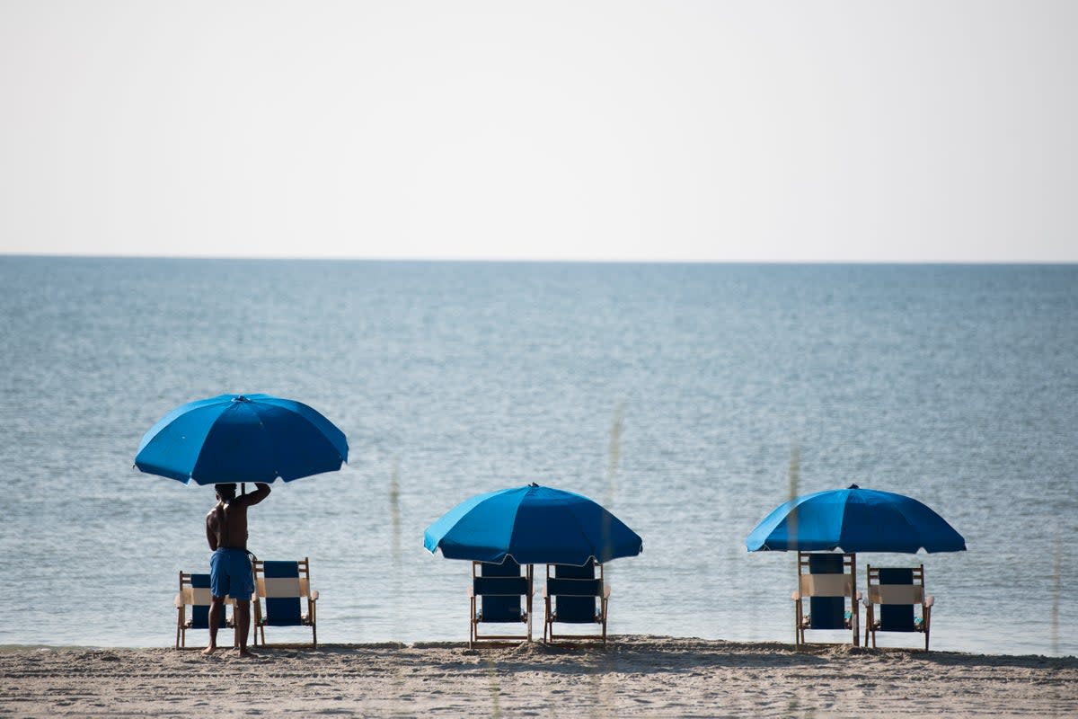 A life guard sets up a beach umbrella the morning of July 4, 2020 in Myrtle Beach, South Carolina.  (Getty Images)