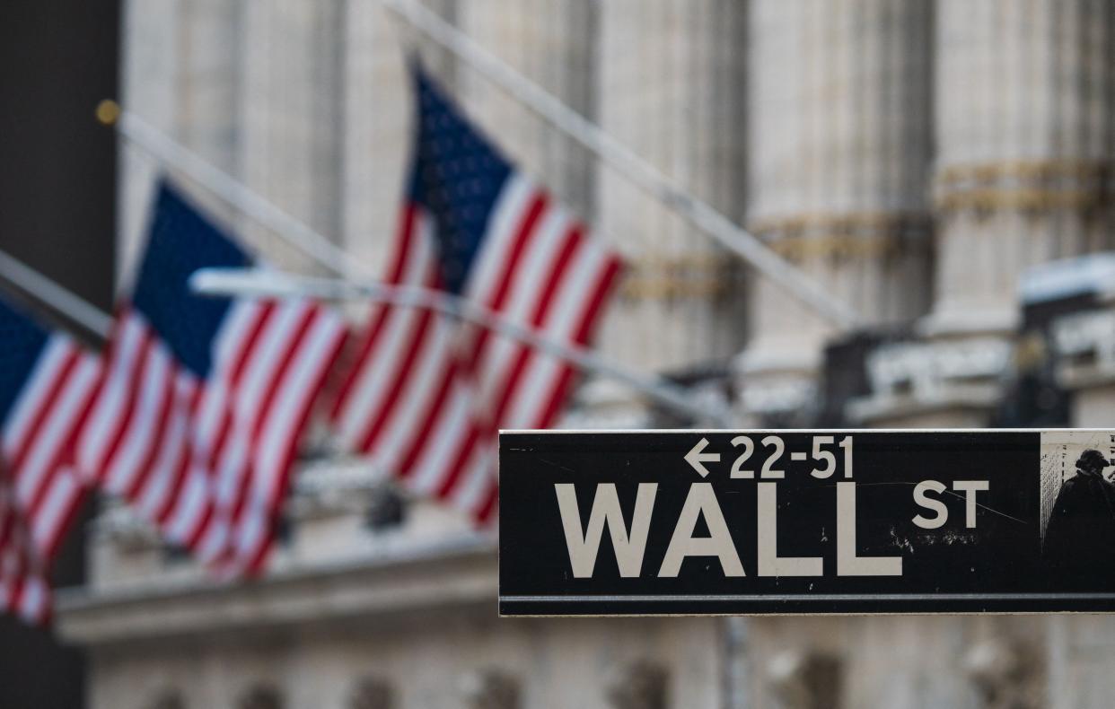 A Wall St sign hangs at the New York Stock Exchange (NYSE) at Wall Street on March 23, 2021 in New York City. (Photo by Angela Weiss / AFP)