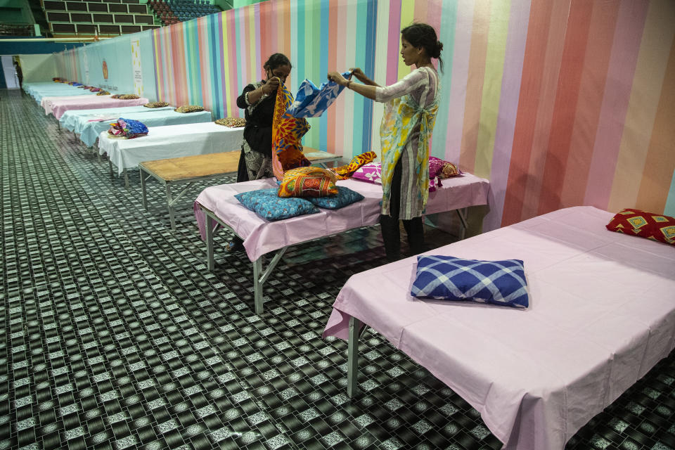 Workers arrange beds at a COVID-19 treatment facility newly set up at an indoor stadium in Gauhati, India, Monday, April 19, 2021. India now has reported more than 15 million coronavirus infections, a total second only to the United States. (AP Photo/Anupam Nath)