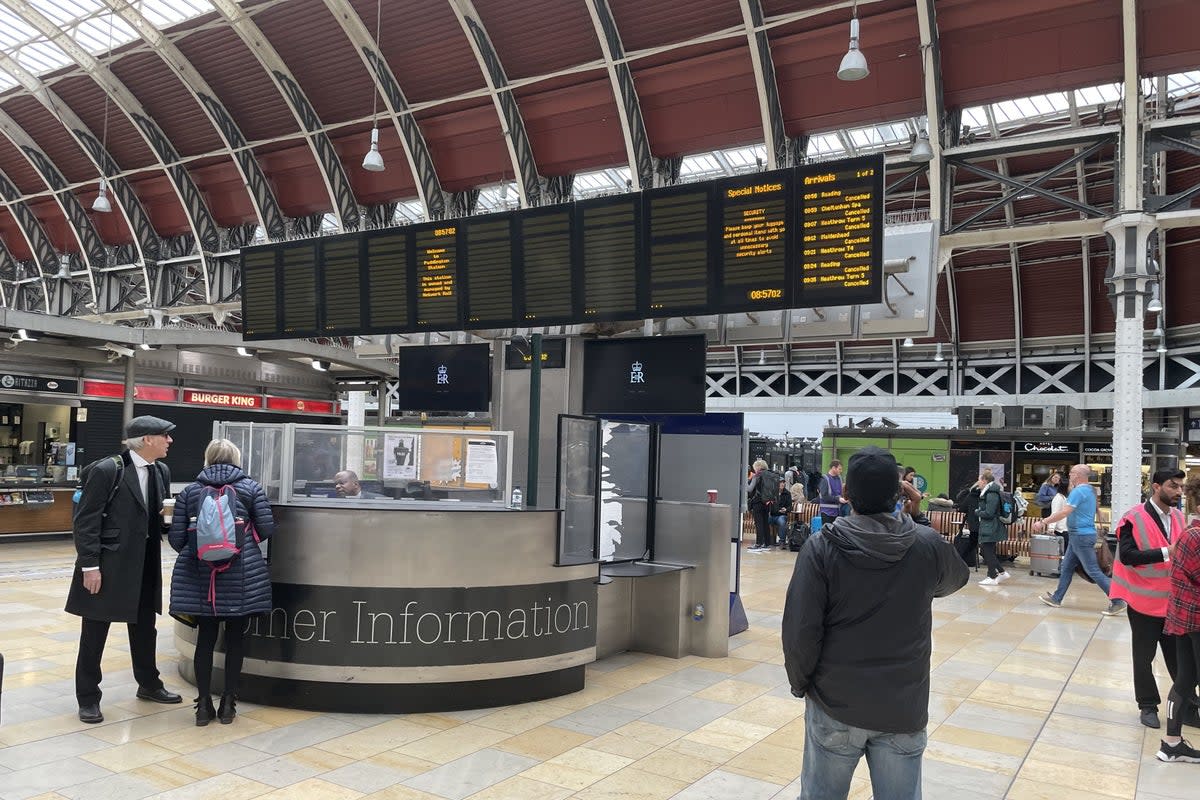 Members of the public look at the travel boards in Paddington Station (PA) (PA Wire)