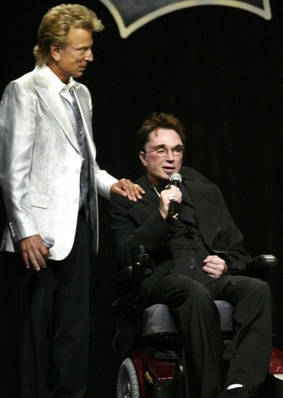 FILE - In this Saturday, Sept. 18, 2004, file photo, magicians Siegfried Fischbacher, left, and Roy Horn appear at the Four Seasons hotel in Las Vegas, where Horn received an award from the Clark County Public Education Foundation. Horn, one half of the longtime Las Vegas illusionist duo Siegfried & Roy, died of complications from the coronavirus, Friday, May 8, 2020. He was 75. (Ralph Fountain/Las Vegas Review-Journal via AP, File)