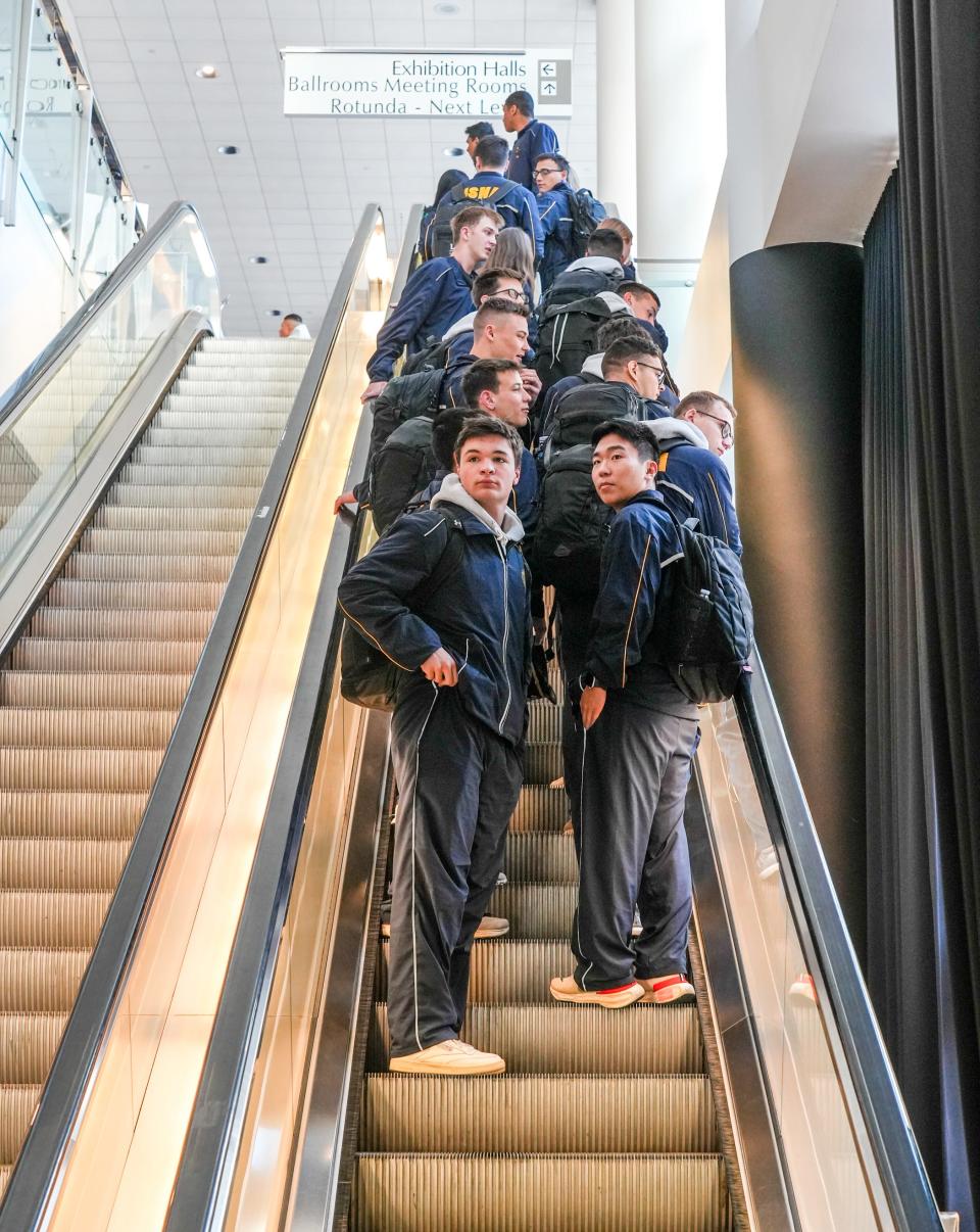 Midshipmen ascend on an escalator in the convention center in Providence. "We know that bragging rights will be on the line when Army and Navy take the field," Gov. Dan McKee said Friday.