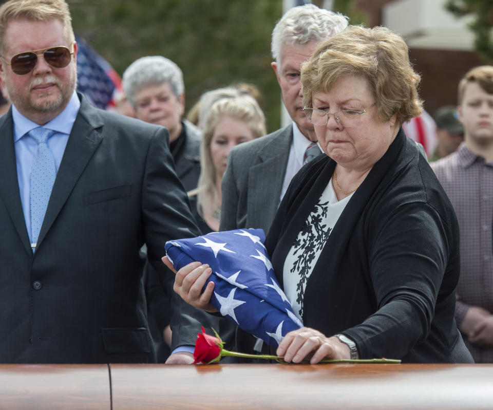 Mary Ann Turner, the daughter of 2nd Lt. Lynn W. Hadfield, places a flower on his casket during his graveside service at Veterans Memorial Park in Bluffdale, Utah, Thursday, March 21, 2019. The Salt Lake City Tribune reported Thursday that Army Air Forces 2nd Lt. Lynn W. Hadfield's remains, returned from Germany, were buried 74 years to the day of Hadfield's crash during a bomber plane run from France to Germany just months before the war's end. (Rick Egan/The Salt Lake Tribune via AP)