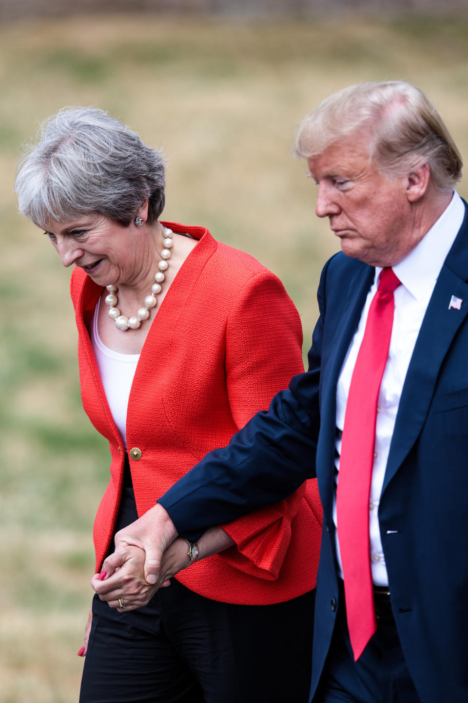 President Trump held British Prime Minister Theresa May’s hand on the way to a meeting. (Photo: Getty Images)