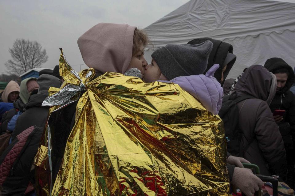 A woman kisses a child after fleeing from the Ukraine and arriving at the border crossing in Medyka, Poland, Monday, March 7, 2022. Russia announced yet another cease-fire and a handful of humanitarian corridors to allow civilians to flee Ukraine. Previous such measures have fallen apart and Moscow’s armed forces continued to pummel some Ukrainian cities with rockets Monday. (AP Photo/Visar Kryeziu)