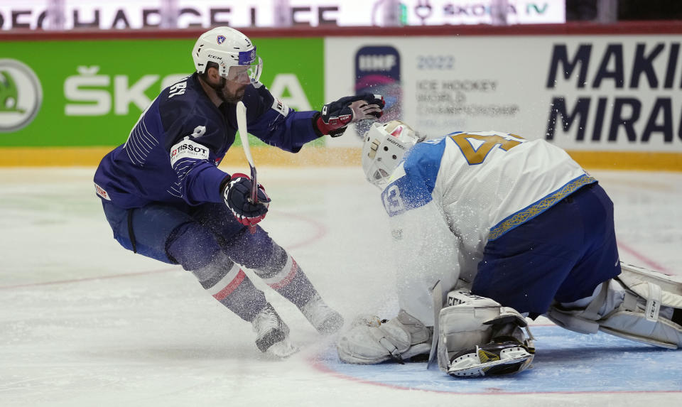 Damien Fleury of France, left, challenges with Kazakhstan's keeper Andrei Shutov during the group A Hockey World Championship match between France and Kazakhstan in Helsinki, Finland, Sunday May 15, 2022. (AP Photo/Martin Meissner)