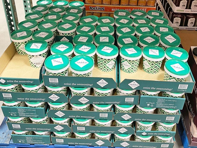 Green canisters of Maldon resealable tub kosher salt flakes in cardboard boxes at Costco