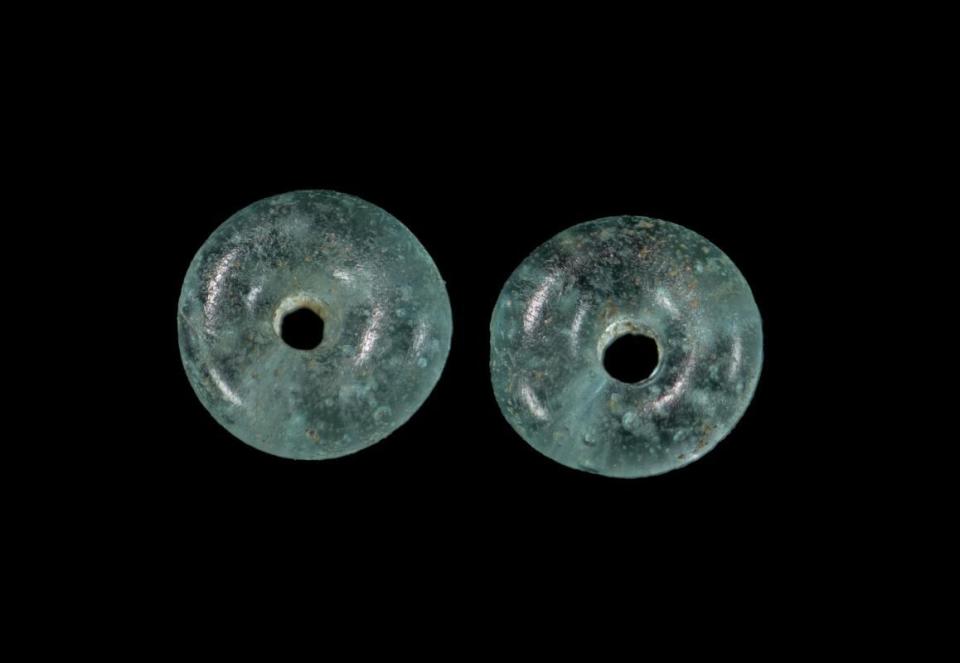 Turquoise glass beads found in the ancient cemetery. / Credit: Wessex Archaeology