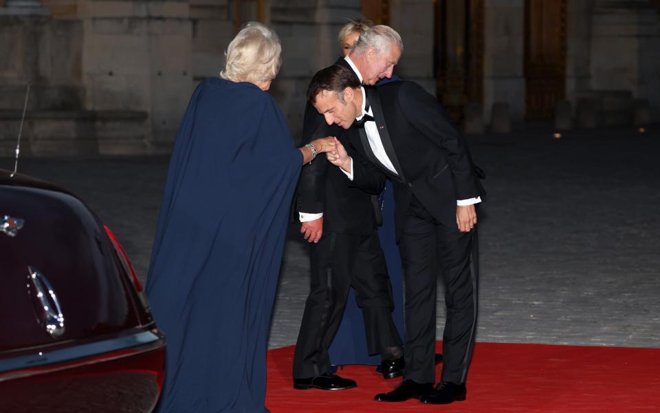 Emmanuel Macron kisses Queen Camilla's hand ahead of state dinner