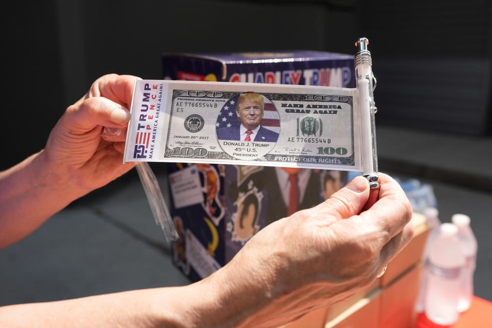 Una persona muestra un billete con la imagen del expresidente Donald Trump el sábado 22 de junio de 2024, antes de un mitin afuera de la Universidad Temple de Filadelfia. (Foto AP/Chris Szagola)