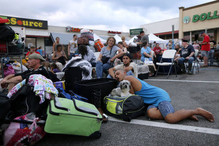 Evacuees who were rescued from the flood waters of Tropical Storm Harvey wait to board school buses bound for Louisiana in Vidor, Texas, U.S., on August 31, 2017. REUTERS/Jonathan Bachman