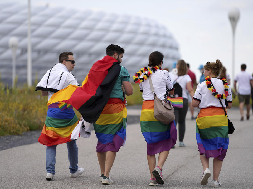 Football supporters are seen with LGBT pride flags on their way to the stadium before the Euro 2020 soccer championship group F match between Germany and Hungary at the Allianz Arena in Munich, Germany,Wednesday, June 23, 2021. (AP Photo/Matthias Schrader)