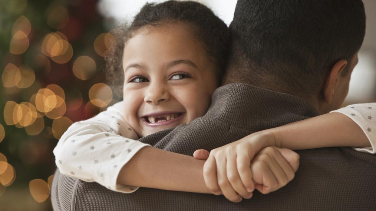 father hugging daughter at christmas