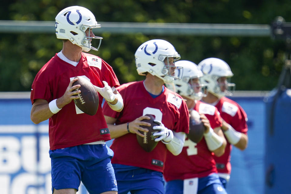 Indianapolis Colts quarterbacks, from left, Matt Ryan, Nick Foles, Sam Ehlinger and Jack Coan drop back to throw during practice at the NFL team's football training camp in Westfield, Ind., Thursday, July 28, 2022. (AP Photo/Michael Conroy)