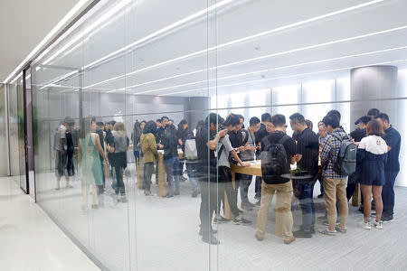 FILE PHOTO: People handle the new Apple iPhone XS and iPhone XS Max during a media tour at an Apple office in Shanghai, China September 21, 2018. REUTERS/Aly Song/File Photo