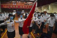 Students attend a flag raising ceremony during the National Security Education Day at a secondary school, in Hong Kong, Thursday, April 15, 2021. Beijing's top official in Hong Kong on Thursday warned foreign forces not to interfere with the "bottom line" of national security in Hong Kong, threatening retaliation even amid ongoing tensions between China and Western powers. (AP Photo/Kin Cheung)